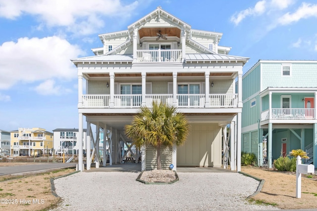 raised beach house with a carport, board and batten siding, and driveway