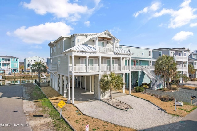 coastal home with a carport, a residential view, driveway, and a balcony