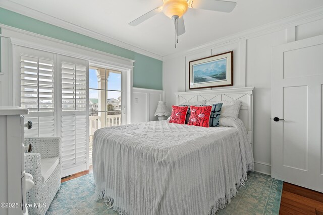 bedroom featuring crown molding, access to outside, a decorative wall, and wood finished floors