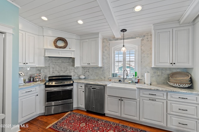 kitchen with a sink, appliances with stainless steel finishes, and white cabinetry