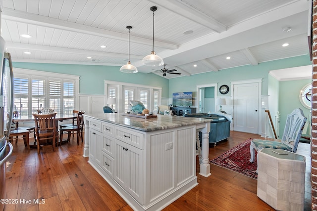 kitchen with dark wood-style floors, lofted ceiling with beams, ceiling fan, hanging light fixtures, and white cabinets