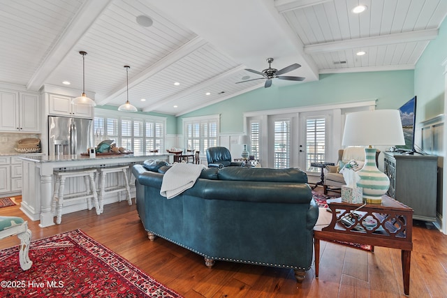 living area with hardwood / wood-style floors, lofted ceiling with beams, a healthy amount of sunlight, and a ceiling fan