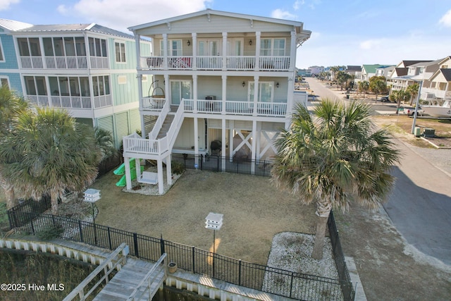 exterior space featuring a balcony, stairs, and fence