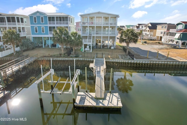 dock area featuring a residential view, boat lift, and a water view