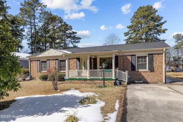 ranch-style house featuring covered porch and brick siding