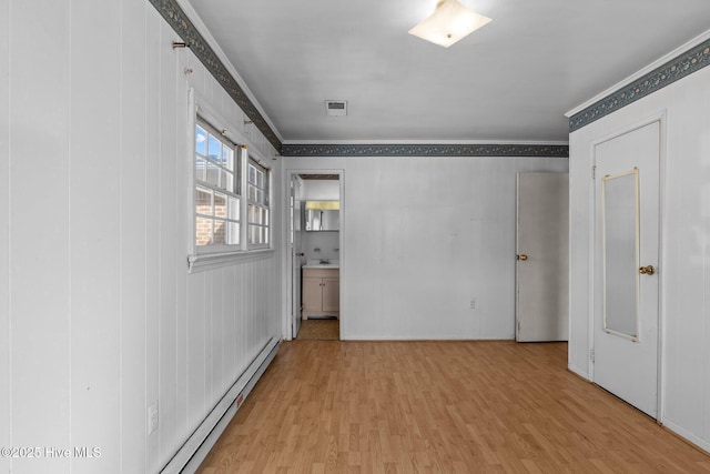 unfurnished room with ornamental molding, visible vents, and light wood-style floors