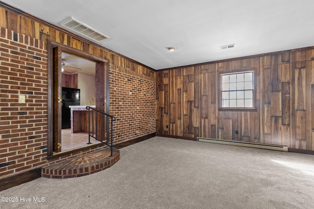 unfurnished room featuring brick wall, baseboard heating, carpet, and visible vents