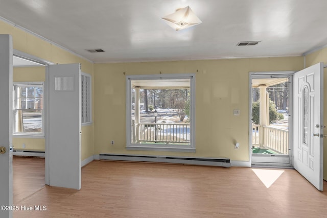 interior space featuring light wood-type flooring, visible vents, and baseboard heating