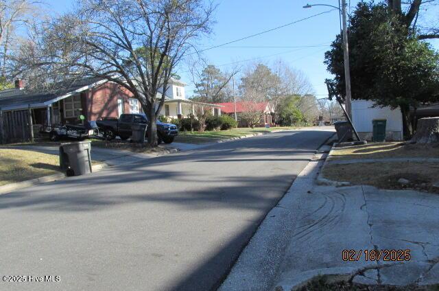 view of street featuring a residential view, curbs, and street lights