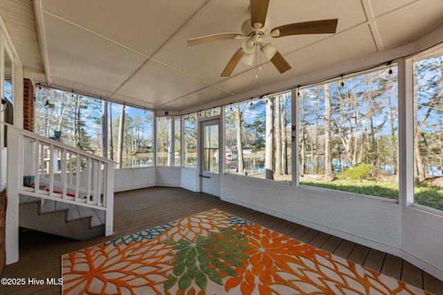 unfurnished sunroom featuring a ceiling fan and a healthy amount of sunlight