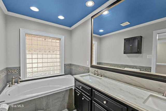 bathroom with double vanity, crown molding, a sink, and a bath