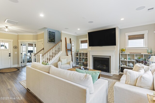 living room with crown molding, recessed lighting, visible vents, wood finished floors, and a chandelier