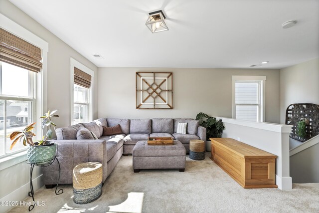 living area featuring carpet floors, visible vents, and baseboards