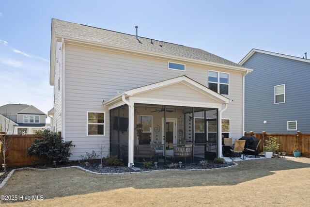 rear view of property with a fenced backyard, a sunroom, a yard, a residential view, and a patio area