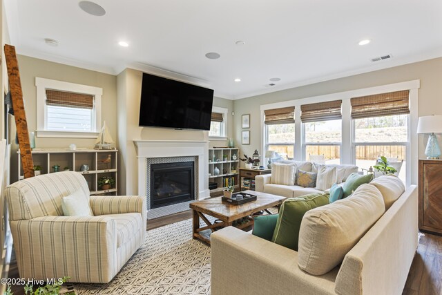 living area featuring an inviting chandelier, crown molding, wood finished floors, and recessed lighting