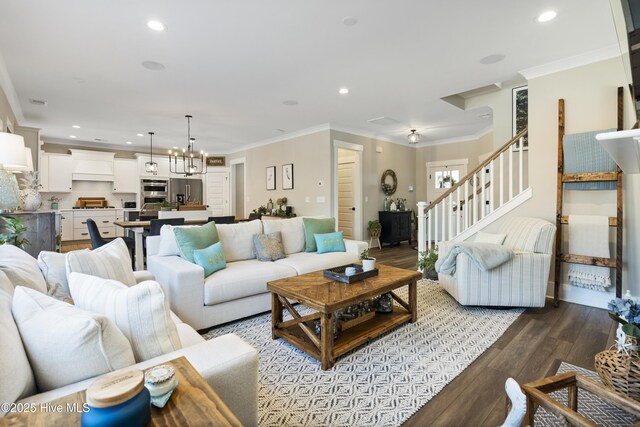 living area featuring crown molding, wood finished floors, plenty of natural light, and stairs