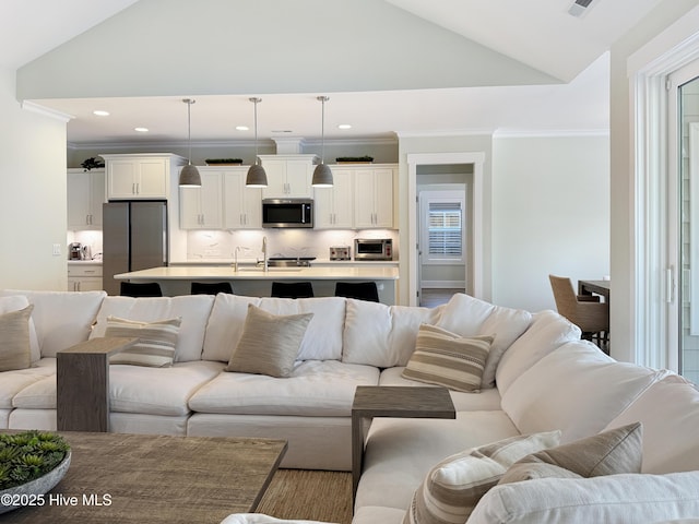 living area featuring lofted ceiling, crown molding, and recessed lighting