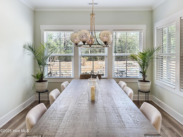 dining room featuring visible vents, baseboards, and wood finished floors