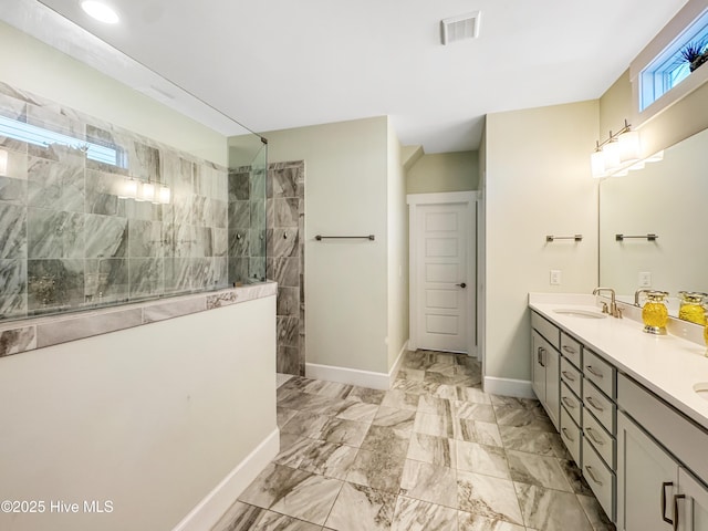 bathroom with a sink, visible vents, marble finish floor, double vanity, and walk in shower