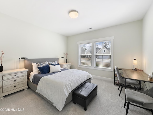 bedroom with baseboards, visible vents, and light colored carpet