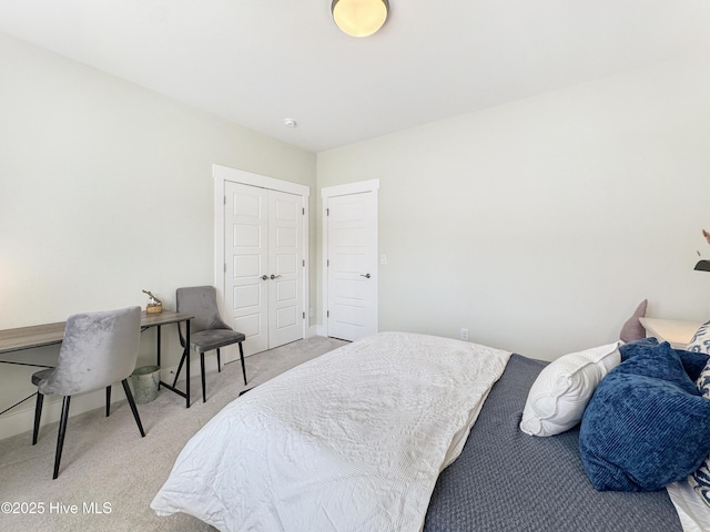 bedroom featuring a closet, light colored carpet, and baseboards