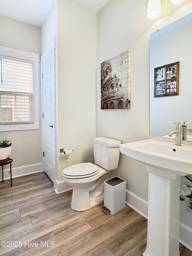 bathroom featuring wood finished floors, toilet, and baseboards