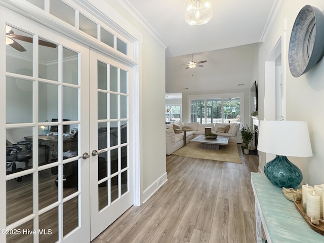 hall with french doors, crown molding, baseboards, and wood finished floors