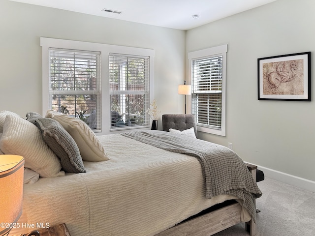 bedroom with multiple windows, carpet flooring, visible vents, and baseboards