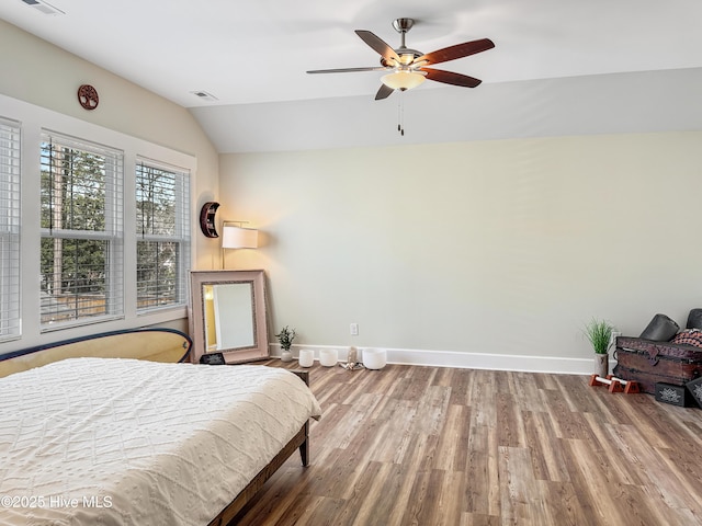 bedroom with lofted ceiling, ceiling fan, wood finished floors, visible vents, and baseboards