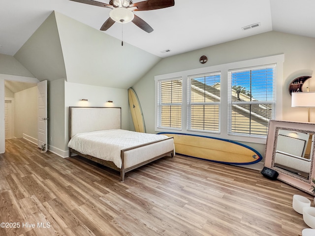 bedroom with vaulted ceiling, light wood-type flooring, visible vents, and a ceiling fan