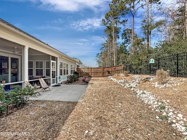 view of yard with a patio, a fenced backyard, and a sunroom