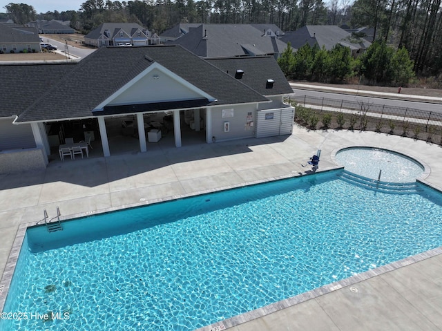 community pool featuring a residential view, a patio, and fence