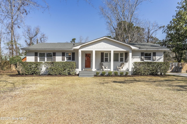 view of front of house with covered porch, a front lawn, and brick siding