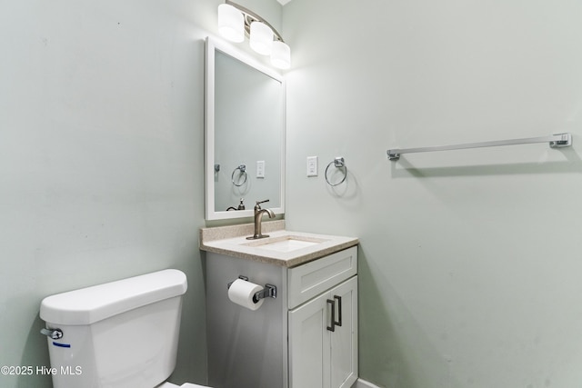 half bath featuring vanity and toilet