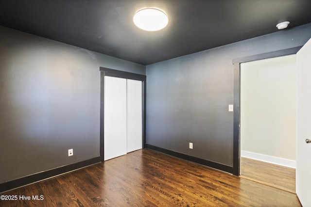 empty room with baseboards and wood finished floors