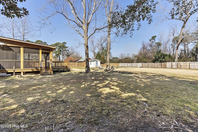 view of yard featuring an outbuilding, a fenced backyard, and a storage shed