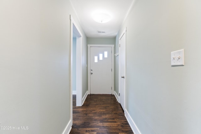 hallway with visible vents, dark wood finished floors, and baseboards