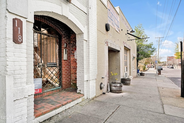 doorway to property featuring brick siding