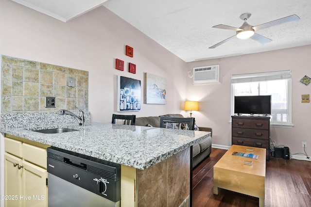 kitchen featuring dishwasher, open floor plan, a wall mounted air conditioner, cream cabinets, and a sink