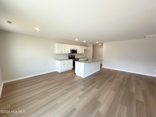 kitchen featuring appliances with stainless steel finishes, open floor plan, visible vents, and white cabinets