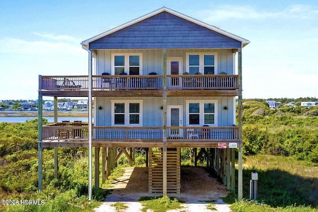 view of front of property featuring a carport, a balcony, driveway, and board and batten siding