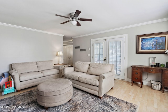 living area featuring light wood-style floors, french doors, ornamental molding, and a ceiling fan