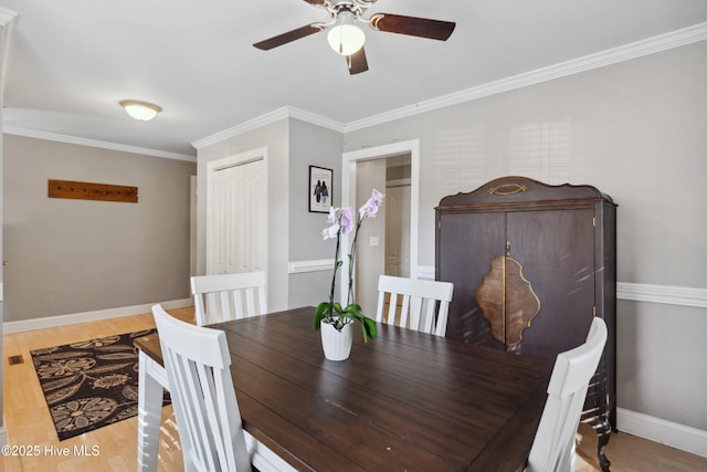 dining room with light wood-style floors, ornamental molding, and baseboards