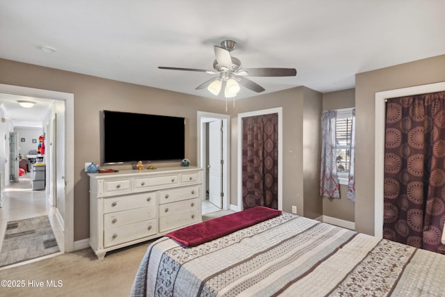 bedroom with light carpet, baseboards, and a ceiling fan