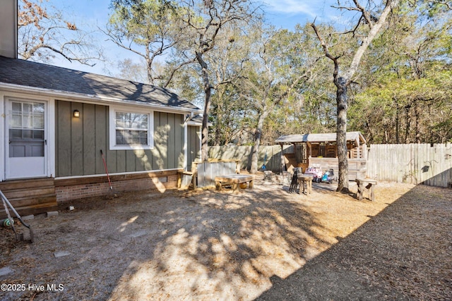 view of yard with a fire pit, a fenced backyard, and entry steps