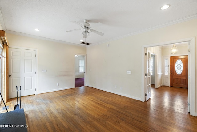 unfurnished living room featuring baseboards, hardwood / wood-style floors, visible vents, and crown molding