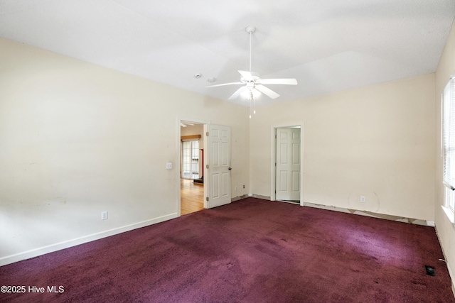 empty room featuring carpet, ceiling fan, lofted ceiling, and baseboards