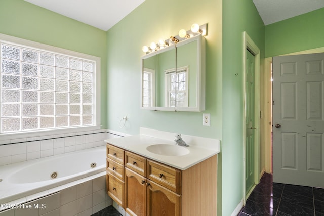 bathroom with tile patterned flooring, a jetted tub, and vanity