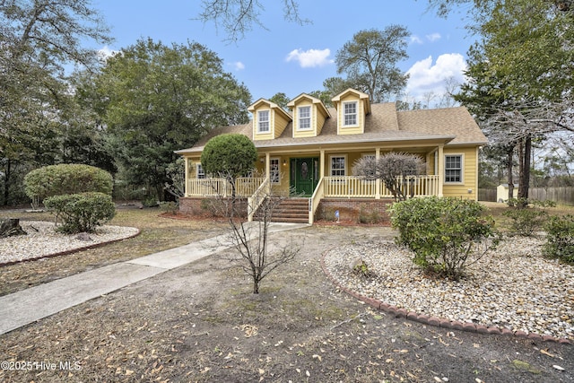 new england style home with a porch and a shingled roof