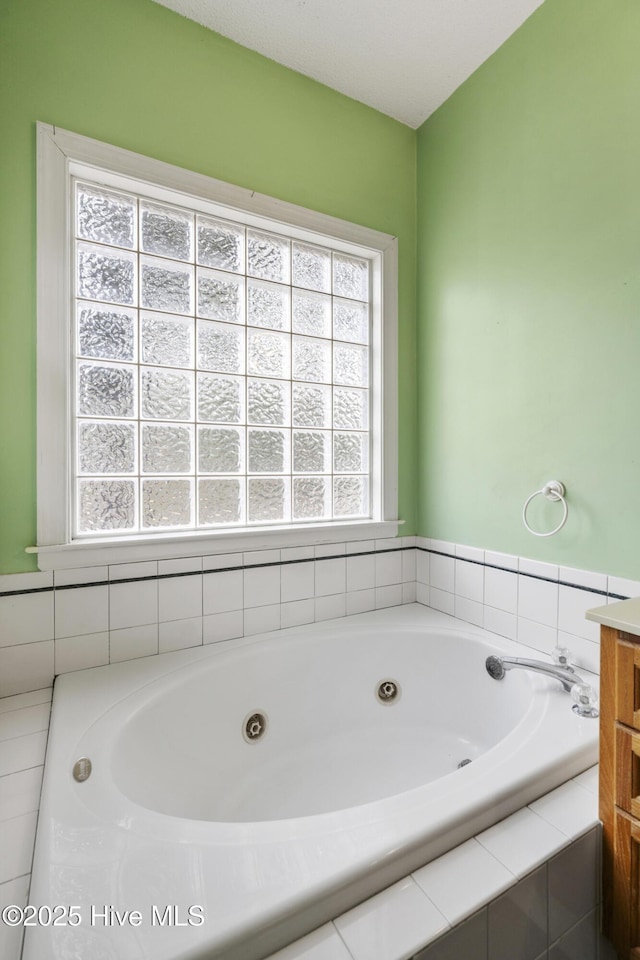 bathroom featuring a jetted tub and vanity